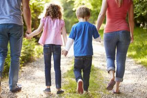 couple walking in the woods with their 2 children