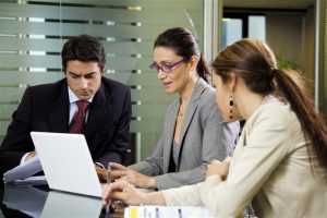 Divorce mediator sitting at desk with couple on computer