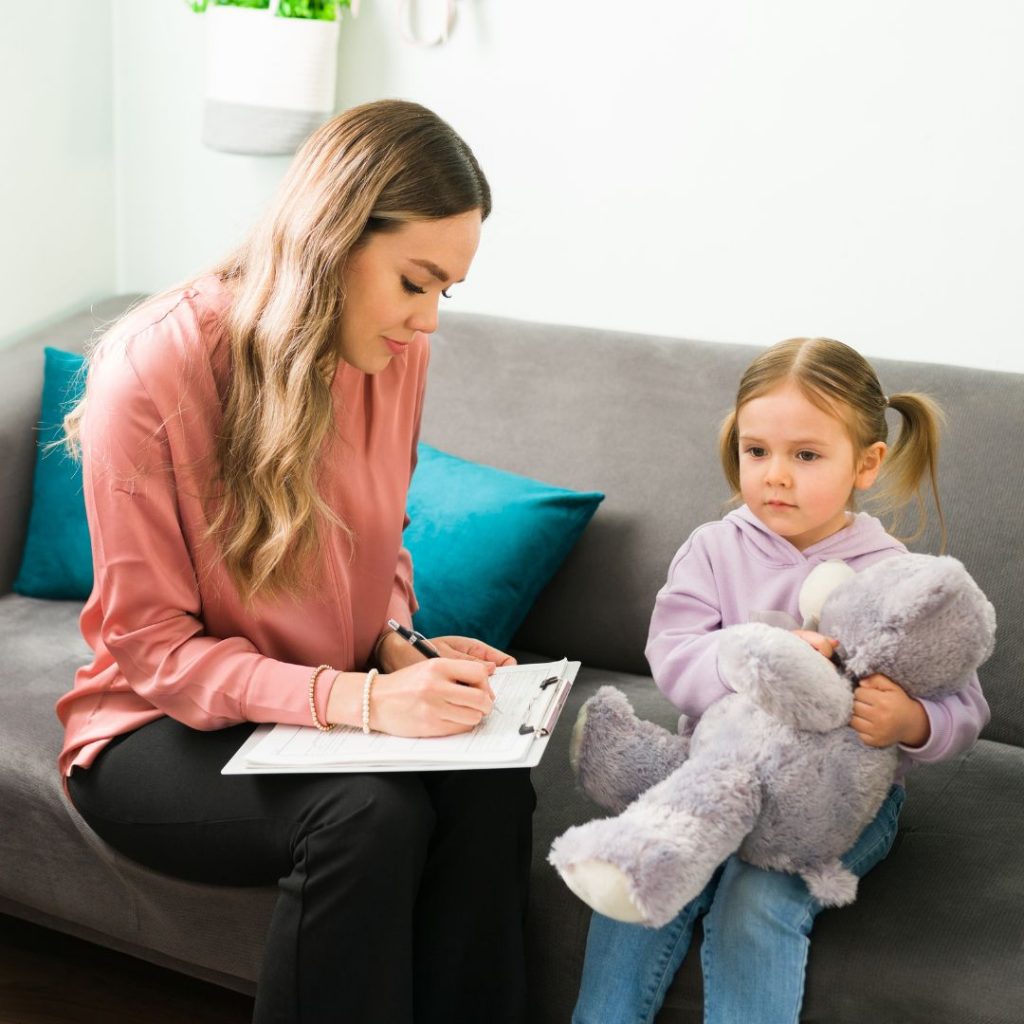 Little girl sitting talking with therapist.